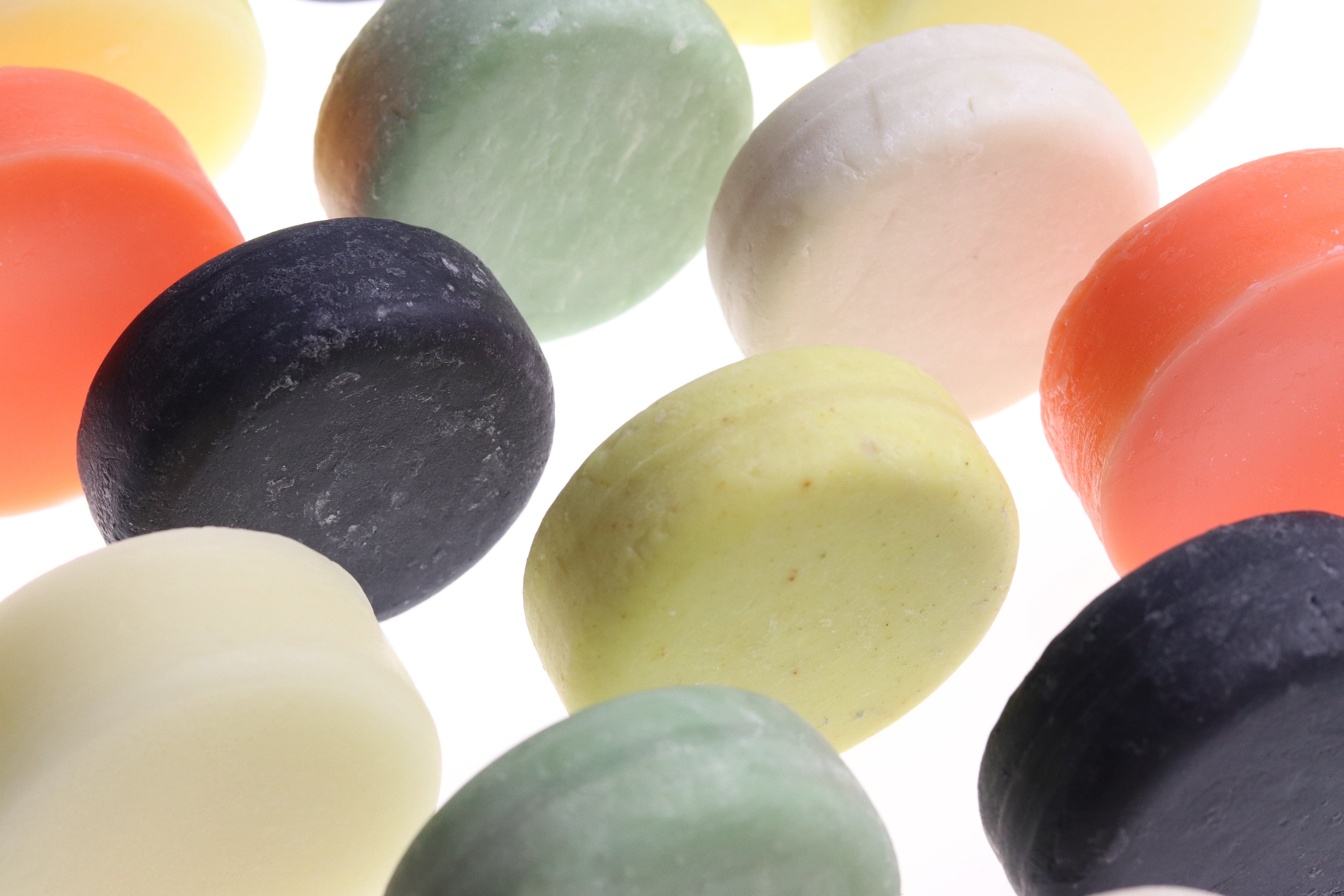 varias barras de shampoo coloridas em pe apoiadas na lateral 
